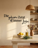 Holzschriftzug „Die geheime Zutat ist immer Liebe“ in Schwarz in einer mediterranen Küche