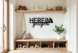 Könnte beinhalten: Schwarze Metall-Wandkunst mit den deutschen Worten "HEREIN getigert" und einer Katzen-Silhouette. Das Schild ist über einer Holzbank mit Schuhen, einem Kissen und einer Pflanze in einem weißen Topf angebracht. Eine Ledertasche und ein gerahmtes Bild befinden sich auf einem Regal.